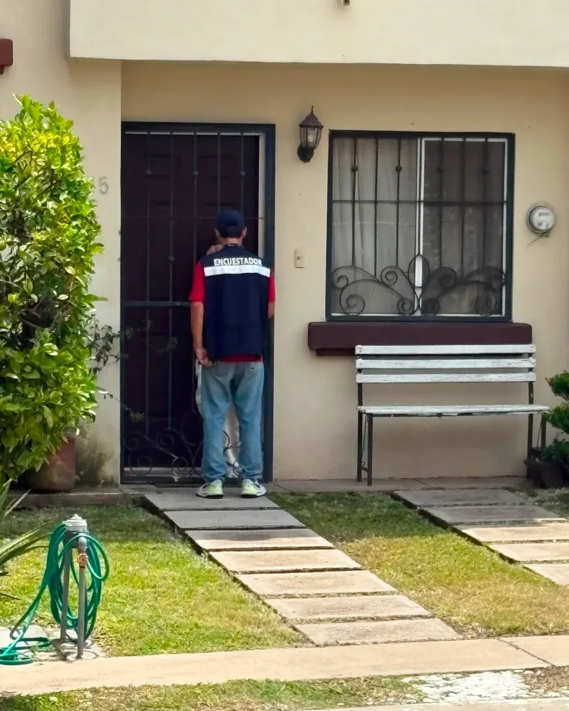 Encuestador de CENESSOD esperando respuesta en la puerta de una vivienda seleccionada probabilísticamente.